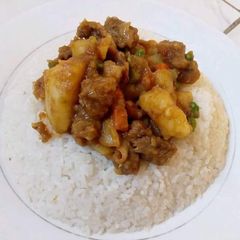A picture of Rice with Beef stew mixed with Matoke.