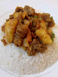 A picture of Rice with Beef stew mixed with Matoke.