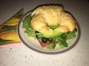 Una foto de sandwich de jamón y rúcula