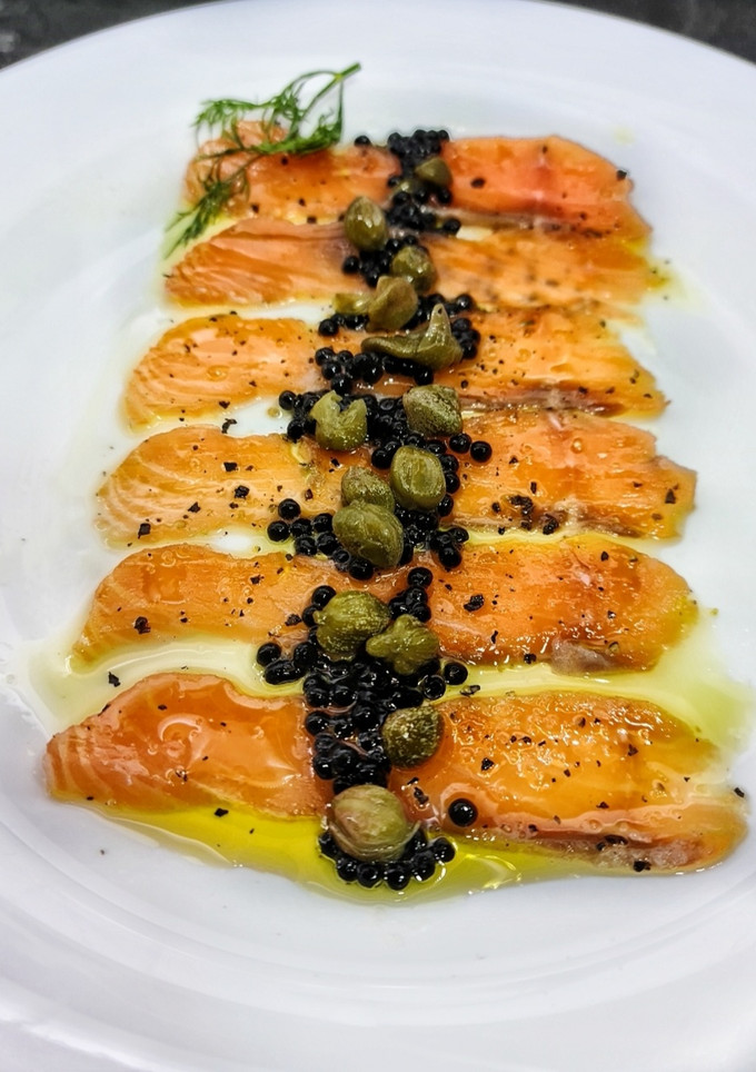 Una foto de Carpaccio de salmón curado con un toque cítrico
