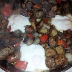 A picture of Skillet fried sausage, mushrooms, peppers and onion with egg.