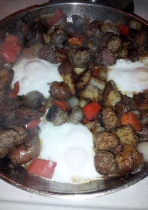 A picture of Skillet fried sausage, mushrooms, peppers and onion with egg.