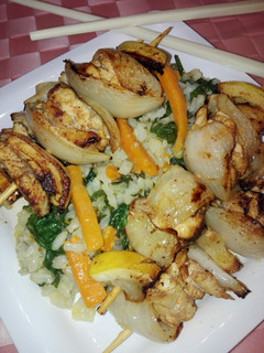 Una foto de Brochetas de lubina en marinada de especias y arroz con verduras