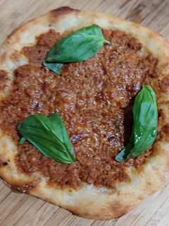 Una foto de Pizza de boloñesa con albahaca
