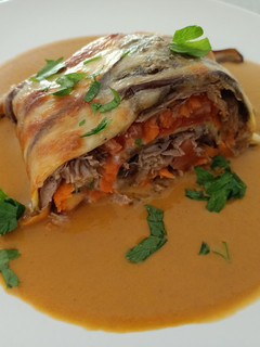 Una foto de Rulo de berenjena relleno de carne y verduras en su salsa
