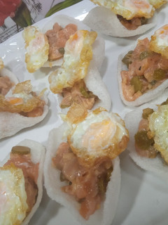 Una foto de Tartar de salmón sobre pan de gamba con huevo de codorniz