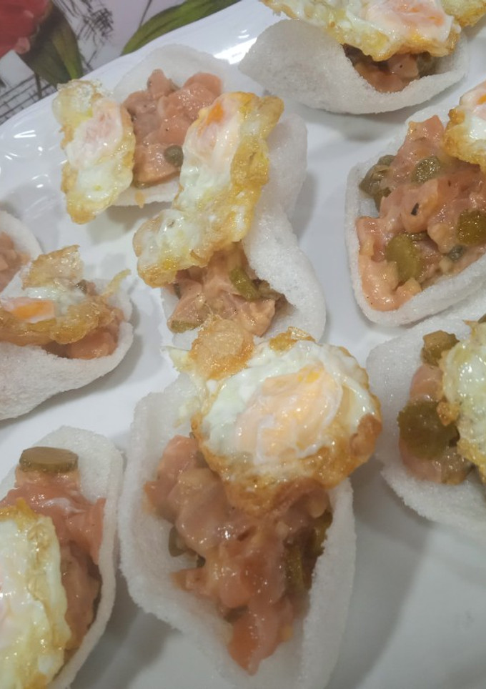 Una foto de Tartar de salmón sobre pan de gamba con huevo de codorniz