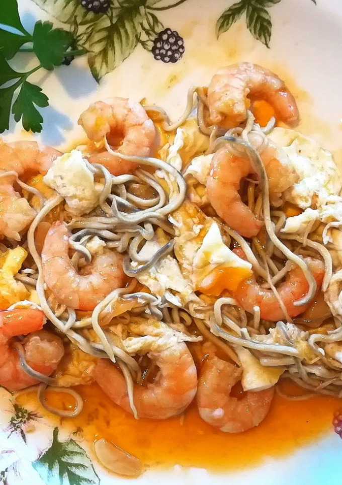 Una foto de Huevos rotos con gulas y langostinos