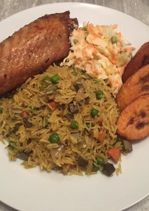 A picture of Fried rice, fried turkey with coleslaw and dodo ( fried plantain.