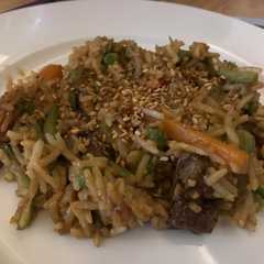 A picture of Fried rice with veggies and meat.