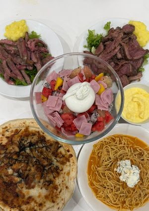 Hình của món Cơm nhà với bò bít tết khoai nghiền, salad hoa quả, sốt phô mai, khoai tây chiên, pizza gà, mỳ ý cua.