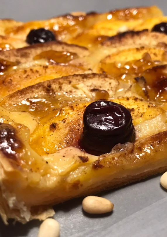 Una foto de Hojaldre de frutas, piñones y limón confitado, sobre crema pastelera