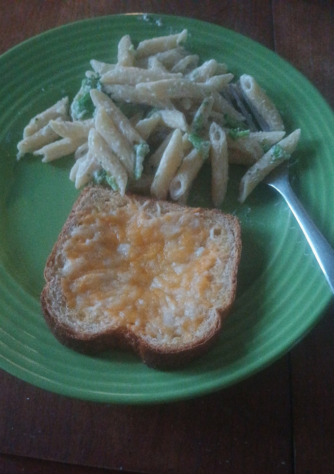 A picture of Broccoli alfredo with garlic bread.