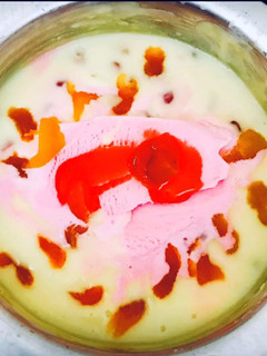 A picture of Dry fruits custard with strawberry ice cream dollop.