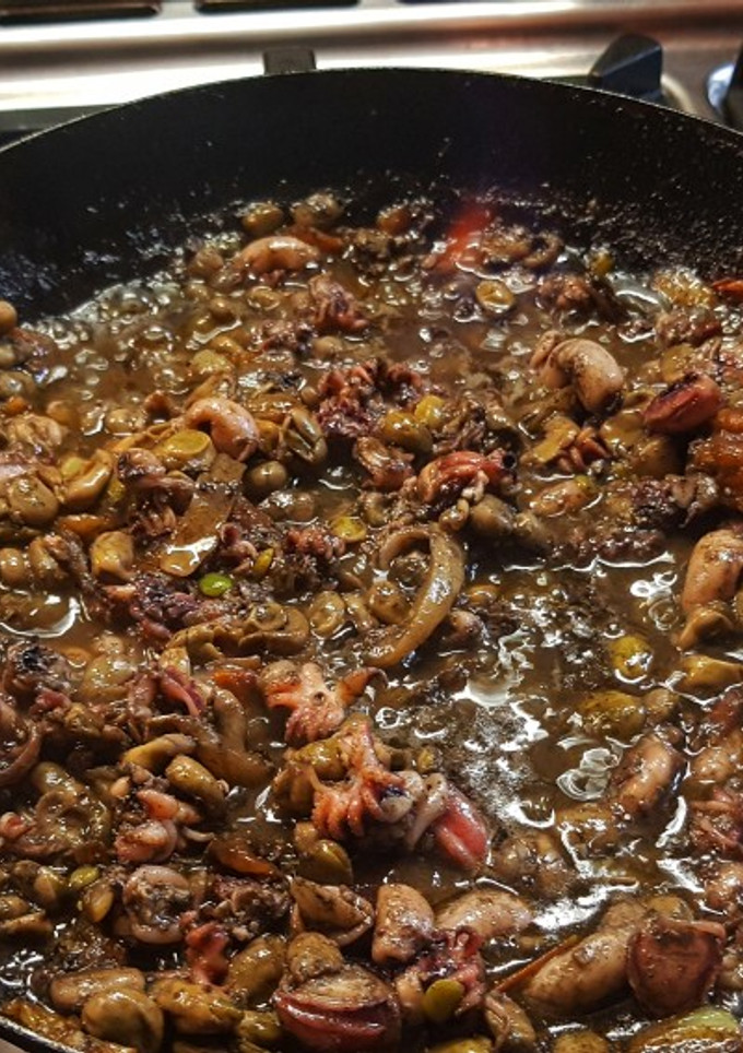 Una foto de Sepionets flamejades amb favetes, ceba i tomata