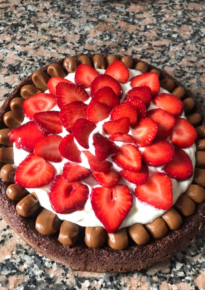 Una foto de Brownie con crema y frutillas