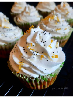 A picture of Gluten-free Oats Lemon Poppy seeds Cupcake + Srikhand Frosting.