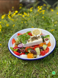 A picture of Vegan Greek Salad with green herbs 🌱🌿.