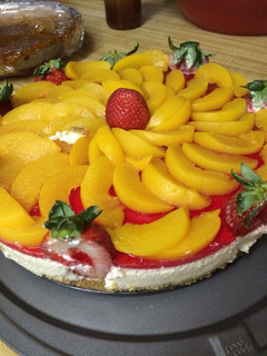 Una foto de Pastel de queso con duraznos y fresas
