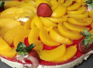 Una foto de Pastel de queso con duraznos y fresas