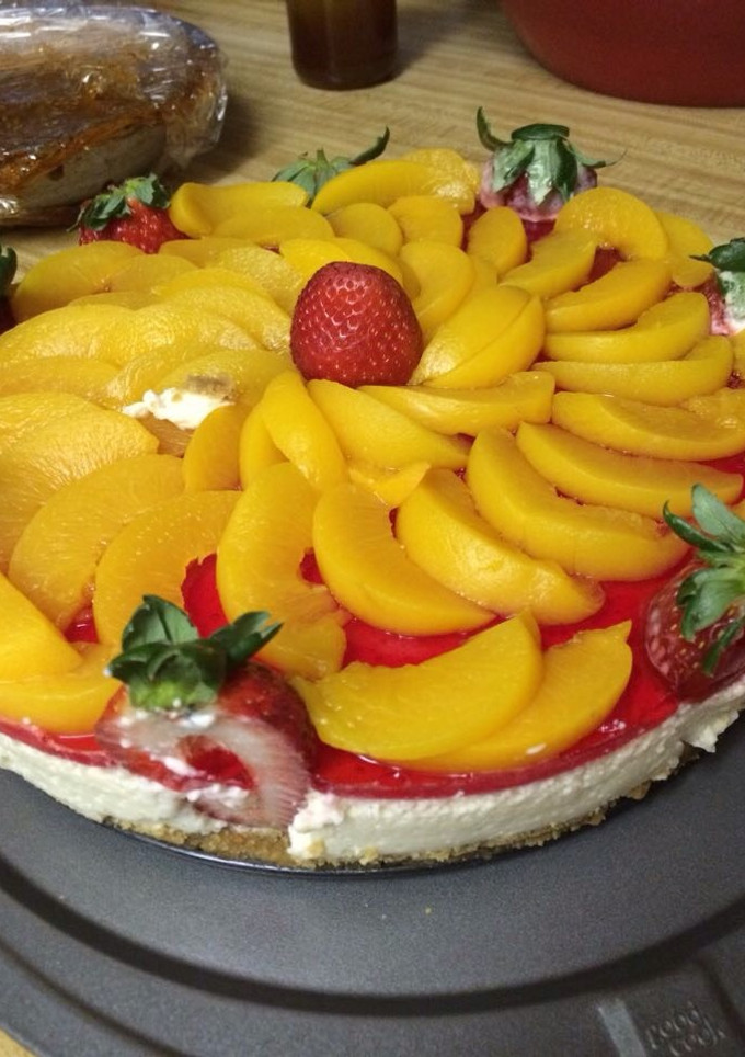 Una foto de Pastel de queso con duraznos y fresas
