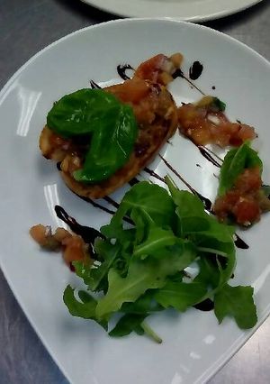 A picture of Tomato and garlic bruchetta with rocket and balsamic glaze.