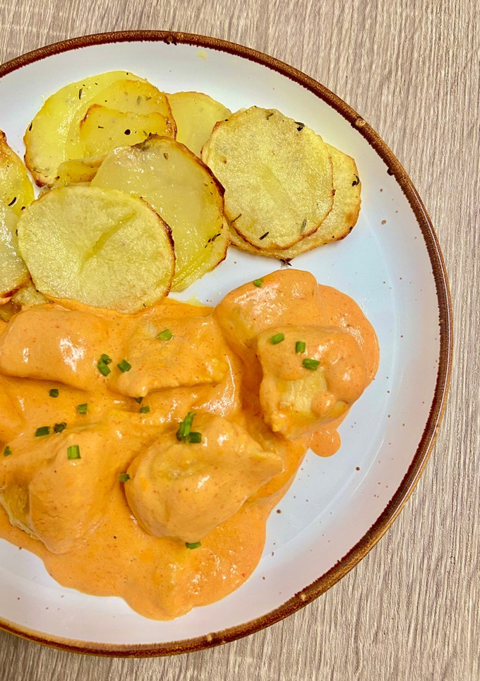 Una foto de Pollo con salsa de pimientos de piquillo y patatas hechas en airfryer