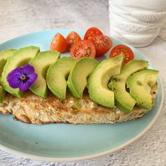 A picture of Avo on toast with fresh baby tomatoes and hot ginger tea ☕️.
