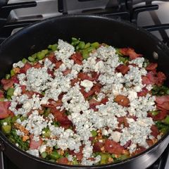 A picture of Asparagus topped with Garlic, Bacon and Blue Cheese.