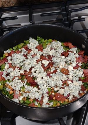 A picture of Asparagus topped with Garlic, Bacon and Blue Cheese.