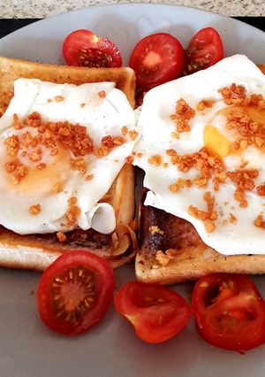 A picture of My Simple Fried Egg on Toast with Bacon Crisps and Tomatoes. 😘.