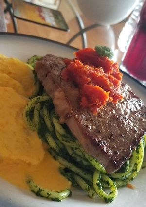 Una foto de Tallarines verdes con solomillo a la parrilla y salsa de tomate
