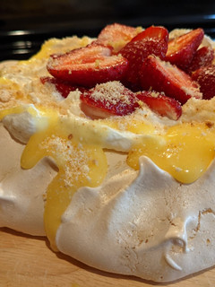 A picture of Pavlova with lemon curd and strawberries.