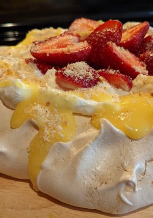 A picture of Pavlova with lemon curd and strawberries.