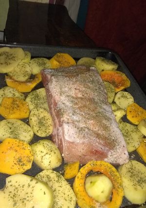 Una foto de Pechito de cerdo con papas y calabazas al horno