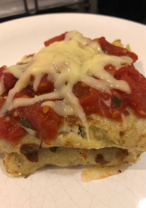 Una foto de Creppe sin tacc de ricotta, achicoria y salsa pomodoro.