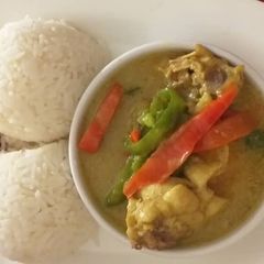 A picture of Chicken curry sauce with rice and fried plantain.