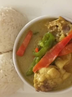 A picture of Chicken curry sauce with rice and fried plantain.