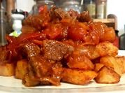 Una foto de lomo con cebolla y pimientos