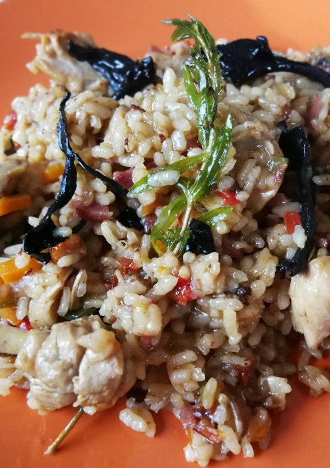 Una foto de Arroz con pollo y jamón curado con setas y tomate secos