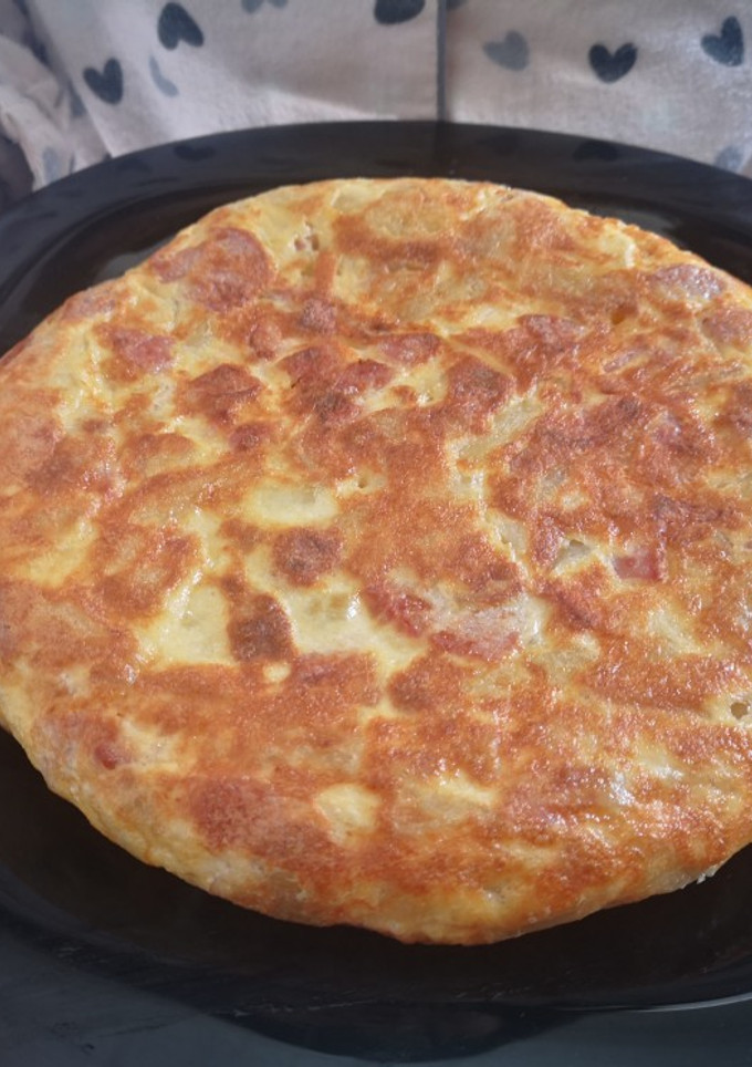 Una foto de Tortilla de patatas con salchichas de bacon y queso