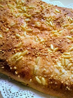 Una foto de Coca de brioche con piñones