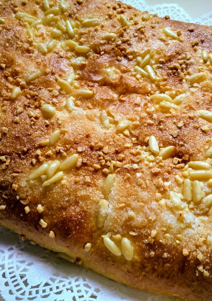 Una foto de Coca de brioche con piñones