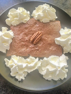 Una foto de Brownie con nata y nueces