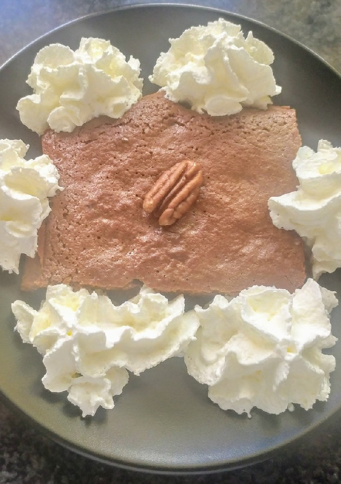 Una foto de Brownie con nata y nueces