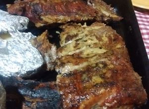 Una foto de Asado a la parrilla de pecho de chancho con salmuera de miel y fernet