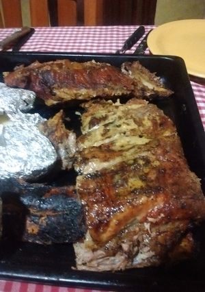 Una foto de Asado a la parrilla de pecho de chancho con salmuera de miel y fernet