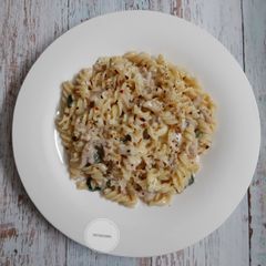 A picture of White sauce pasta with chicken salami.