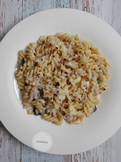 A picture of White sauce pasta with chicken salami.