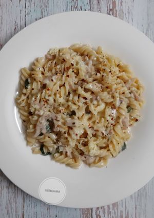 A picture of White sauce pasta with chicken salami.